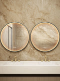Two round mirrors on a marble wall above a bathroom vanity.