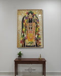 Decorative wall art of a deity with flowers on a white wall above a wooden console table.