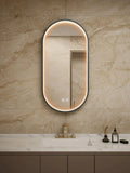 Bathroom vanity with a mirror and sink against a beige tiled wall.